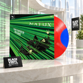 The Matrix de Don Davis en vinilo rojo y azul, en una escena editorial luminosa con elementos BVRS