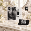 Cassette de Ariana Grande en un tocador luminoso con flores blancas y tarjetas de Black Vinyl Records Spain