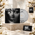 CD de Ariana Grande con portada en blanco y negro, magnolias blancas y tarjetas de Black Vinyl Records Spain