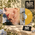 Vinilo amarillo con portada e inserto en una escena botánica con cartel y tarjeta de Black Vinyl Records Spain