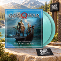 God of War de Bear McCreary con dos vinilos turquesa en un paisaje de lago y montañas, escena BVRS